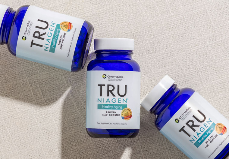 Man holding Tru Niagen NAD supplement bottle with glass of water